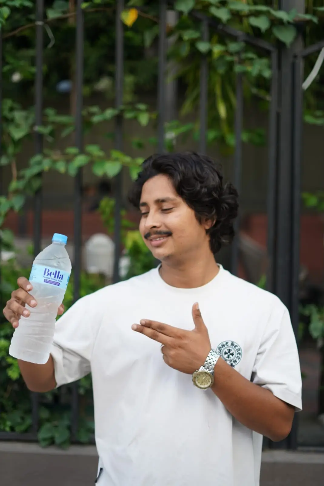 Man holding Bella bottle outdoors